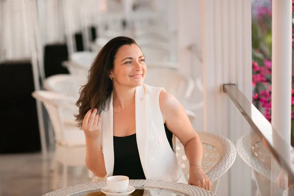 Mulher americana elegante em dreess amarelo posou no café com xícara de cappuccino às mãos . Imagem De Stock