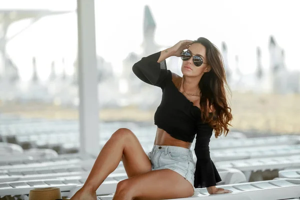 Gebräuntes Mädchen mit langen Haaren und stylischen Shorts am Strand — Stockfoto