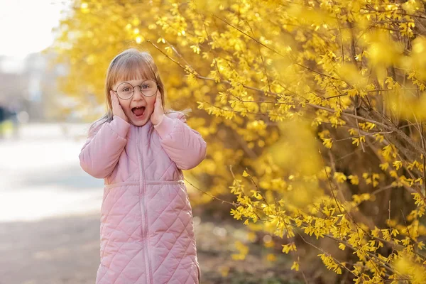 가을 공원에서 트렌디 한 핑크 코트를 입고 세련된 아이 소녀 5-6 세. 카메라를 보고 있습니다. 가을 시즌. 어린 시절. 그녀는 모델로 포즈. — 스톡 사진