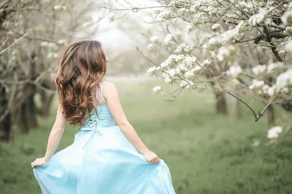 En kysser nygifta par spenderar tid i blommande trädgård. — Stockfoto