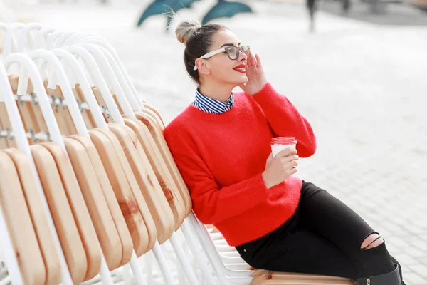 Een mooie vrouw in glazen, met een glas koffie — Stockfoto