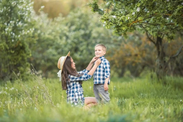 Een lachende kinderen broer en zus spelen in een bos — Stockfoto