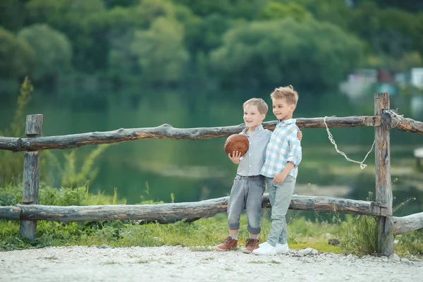 Un niño se para cerca de la valla de madera en un harén — Foto de Stock