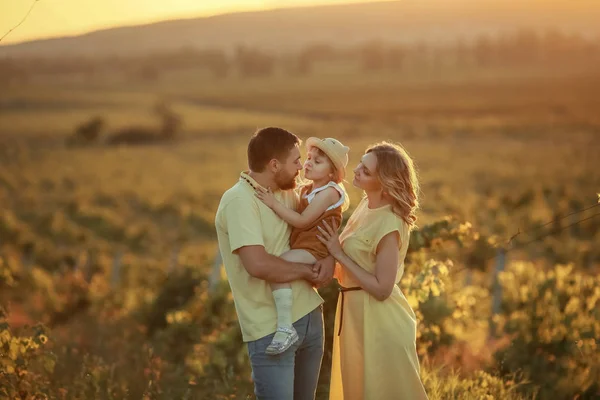 Een gelukkige familie wandeling geschiedenis. moeder en baby knuffelen in een weide gele bloemen op de natuur in de zomer — Stockfoto