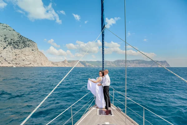 Casal jovem Relaxando em um iate. Feliz homem rico e uma mulher de barco privado têm viagem de mar . — Fotografia de Stock