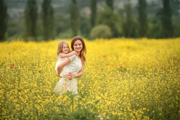 Madre e figlia felice bambino insieme a fiori di tarassaco gialli nel giorno estivo — Foto Stock