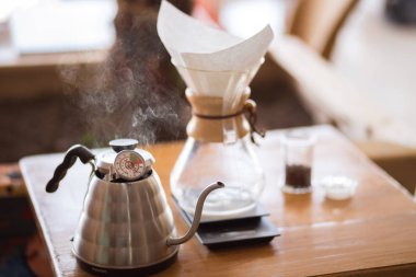 Ahşap tezgahta kahve demleyen aletleri kapatın.