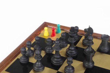 Self confidence colorfuls peons team cornered, standing in front of a black chess army before confrontation. clipart