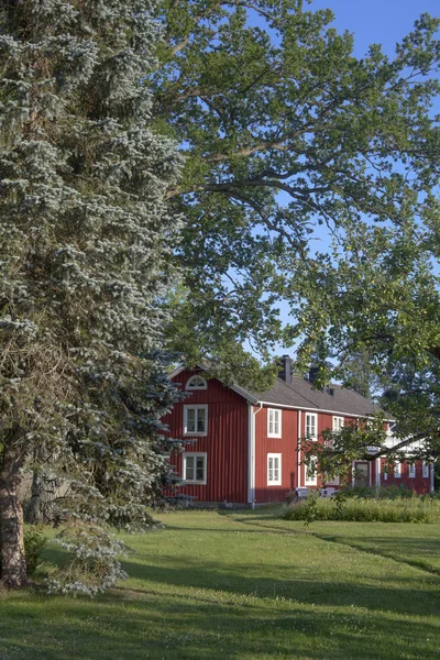 Kırsal kesimde, yazın doğanın ortasında, güzel, kırmızı bir İsveç ahşap ev.