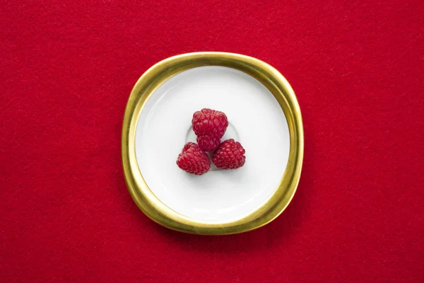 Raspberries Placed Golden White Dish Isolated Red Background — Stock Fotó