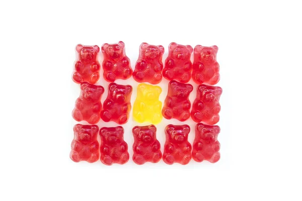 Detail of roup of red gummy bears and one in yellow with isolated background