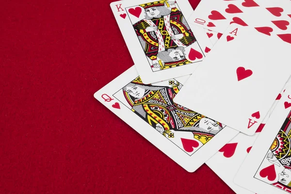 Detail of heart deck poker playing cars in red background.