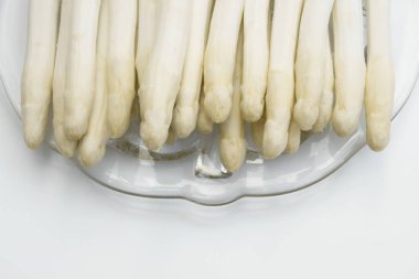 İzole edilmiş bir tabağa yerleştirilmiş beyaz kuşkonmaz grubu.