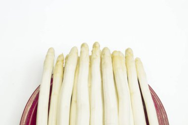 İzole edilmiş bir tabağa yerleştirilmiş beyaz kuşkonmaz grubu.