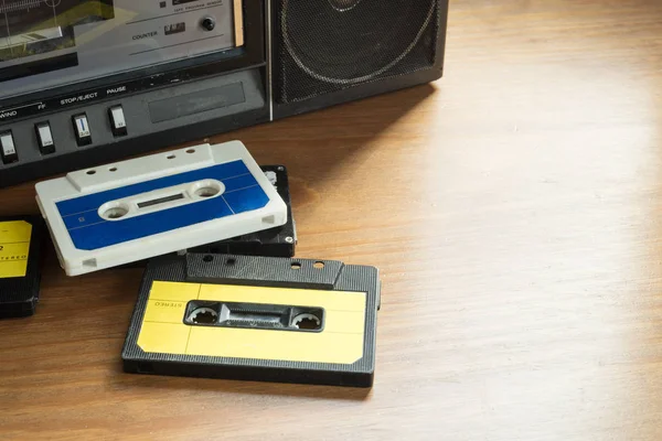 木製のテーブル ラジオ カセット プレーヤーとビンテージのカセット テープ — ストック写真