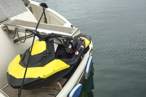 Yellow black jet ski placed on a boat at the sea