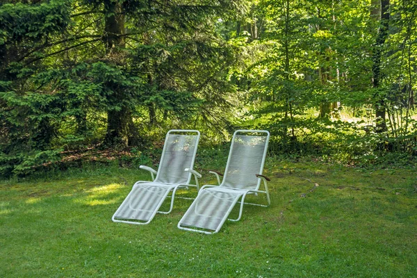 chaise lounges on a lawn for outdoor recreation