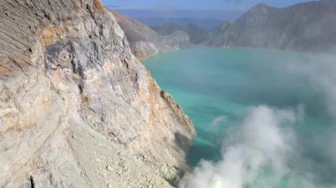 Doğu Java, Endonezya 'daki Ijen volkan kraterinin hava görüntüsü. Kayalık uçurumlar ve volkanik manzaralarla çevrili çarpıcı turkuaz asitli göl. Asya 'daki ünlü seyahat merkezi..