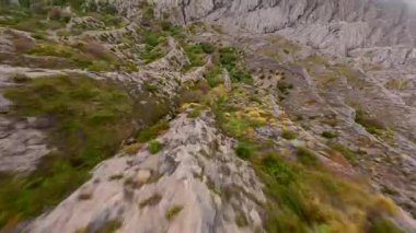 Doğu Java, Endonezya 'daki engebeli volkanik uçurumlarda ve kayalık tepelerde FPV insansız hava aracı uçuşu. Dinamik hareket dramatik manzarayı vurgular, macera ve doğa temaları için mükemmeldir..