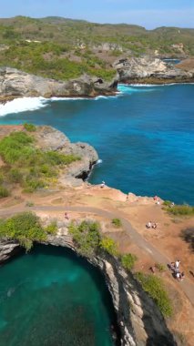 Bali 'de Nusa Penida' daki Broken Beach ve Angels Billabong 'un hava manzarası. Doğal kemer ve turkuaz sulara sahip ünlü kıyı kayaları oluşumu. Seyahat ve doğa temaları için ideal.