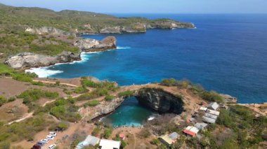 Bali 'de Nusa Penida' daki Broken Beach ve Angels Billabong 'un hava manzarası. Doğal kemer ve turkuaz sulara sahip ünlü kıyı kayaları oluşumu. Seyahat ve doğa temaları için ideal.