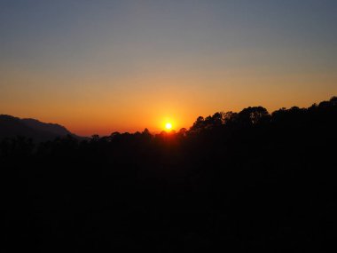 Chiang Dao Dağı'nda siluet gün batımı, akşam güneşin turuncu ve altın rengi.