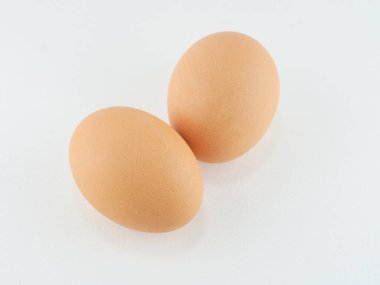 2 yumurta, taze ve temiz kahverengi kabuklu, beyaz arka planda.