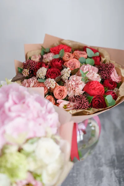 Koncepcja florystyka. Dwa bukiet pięknych kwiatów na szara tabela. Kolory wiosny. Praca w kwiaciarni Kwiaciarnia. — Zdjęcie stockowe