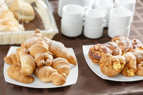 Färska croissanter på vit platta. Franska traditionella bakverk. Frukost i hotel smörgåsbord. — Stockfoto