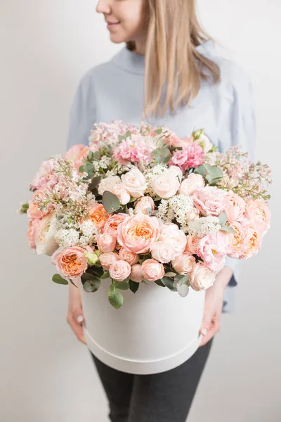 Set de flores. hermoso ramo de lujo en mano de mujer. el trabajo de la floristería en una florería. caja redonda blanca — Foto de Stock