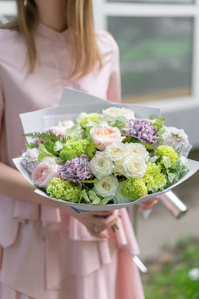 Hermoso ramo de lujo de flores mixtas en mano de mujer. el trabajo de la floristería en una florería. Un pequeño negocio familiar. foto exterior — Foto de Stock