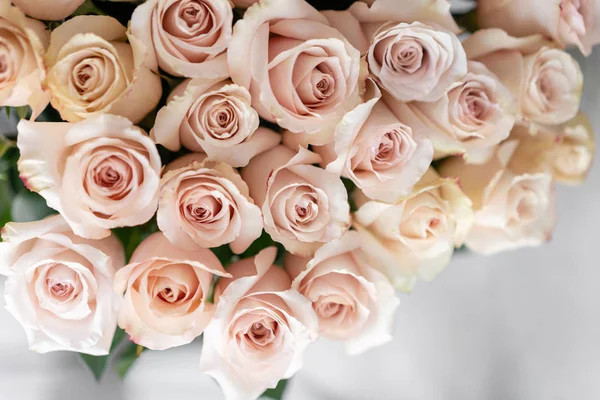 Rosas rosa pastel. Buquê de belas flores na mesa de madeira. Conceito de floricultura. o trabalho da florista em uma loja de flores. Foto vertical — Fotografia de Stock