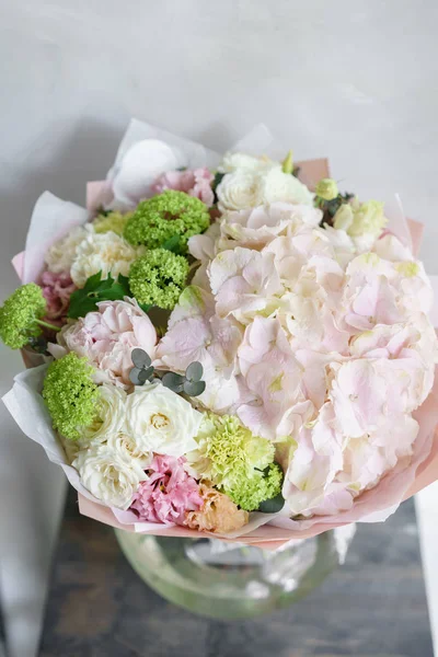 Konsep Floristry. Buket bunga yang indah di atas meja abu-abu. Warna musim semi. karya tukang bunga di sebuah toko bunga . — Stok Foto