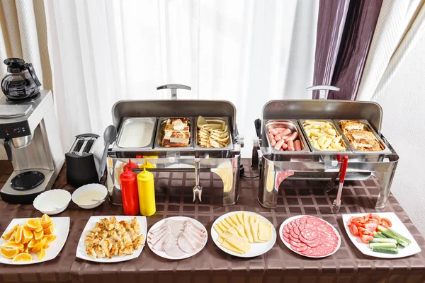 Breakfast in hotel smorgasbord. Buffet trays heated ready for service. Plates with different food