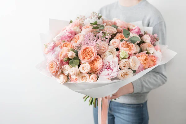 Boeket van mooie bloemen in womens handen. Bloemschikken concept. Lente kleuren. het werk van de bloemist op een bloemenwinkel. — Stockfoto