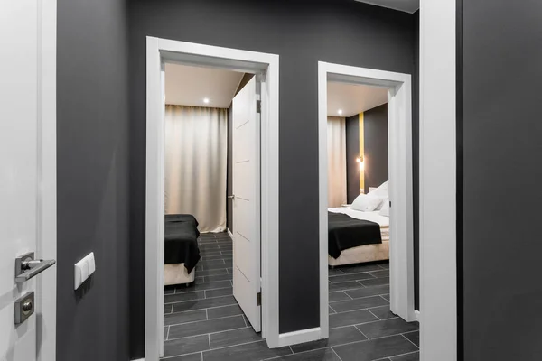 El pasillo entre las habitaciones. Habitación familiar barata. Hotel standart de dos dormitorios. interior simple y elegante. iluminación interior —  Fotos de Stock