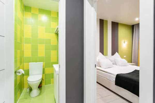 Łazienka z prysznicem, miska WC i umywalką. Hotel standart sypialni. proste i stylowe wnętrza. Oświetlenie wnętrza — Zdjęcie stockowe