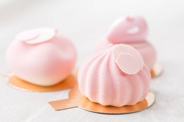 Pembe köpük-kek. Fransız tatlı ve çiçekler okaliptüs beyaz zemin üzerinde. Pastel renkler