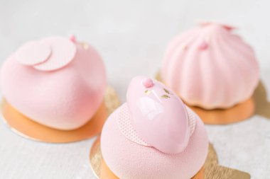 Pembe köpük-kek. Fransız tatlı ve çiçekler okaliptüs beyaz zemin üzerinde. Pastel renkler