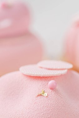 Pembe köpük-kek. Fransız tatlı ve çiçekler okaliptüs beyaz zemin üzerinde. Pastel renkler