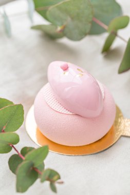 Pembe köpük-kek. Fransız tatlı ve çiçekler okaliptüs beyaz zemin üzerinde. Pastel renkler