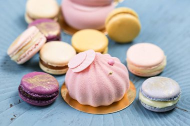 Pembe köpük-kek. Fransız acıbadem kurabiyesi okaliptüs turkuaz bir arka plan üzerinde tatlı ve çiçekler. Pastel renkler