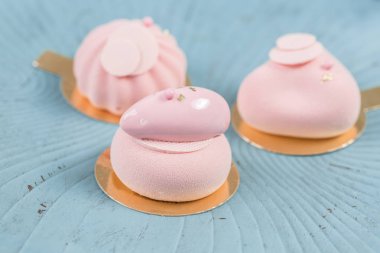 Pembe köpük-kek. Fransız tatlı ve çiçekler okaliptüs turkuaz bir arka plan üzerinde. Pastel renkler