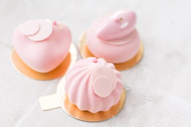 Pembe köpük-kek. Fransız tatlı ve çiçekler okaliptüs beyaz zemin üzerinde. Pastel renkler