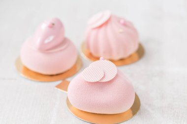 Pembe köpük-kek. Fransız tatlı ve çiçekler okaliptüs beyaz zemin üzerinde. Pastel renkler