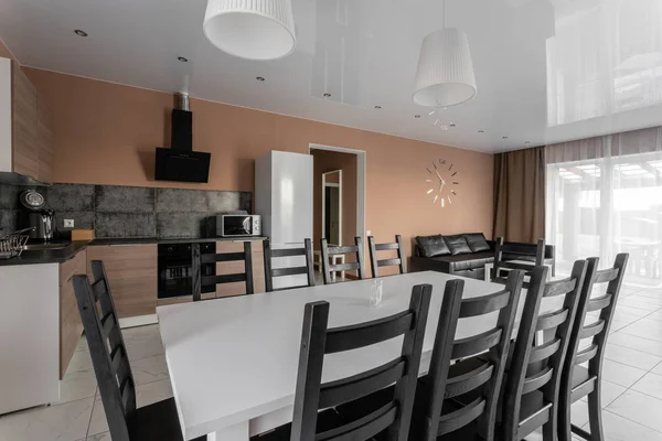 Tavolo da pranzo per dieci persone. Moderno stile minimalismo salotto interno. Soggiorno semplice ed economico con cucina. luce del giorno al mattino — Foto Stock