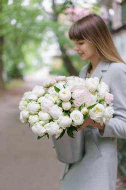 seçici odak çiçek üzerinde. Woomans elinde beyaz peonies güzel buket. Çiçek kompozisyon, gün ışığı. Duvar kağıdı. Dikey fotoğraf