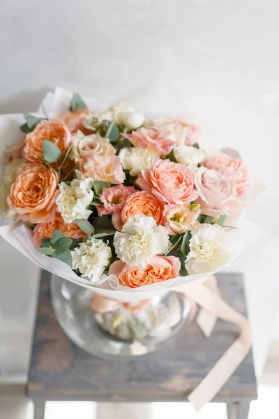 pastel turuncu ve Pembe buket güzel ahşap masa üzerinde. Floristik kavramı. Bahar renkleri. Çiçekçi Çiçek dükkanında çalışır. Dikey fotoğraf