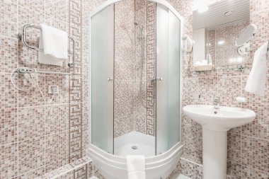 Banyo içinde odalar bir daire veya otel. Temiz beyaz havlu ve bornoz kullanmaya hazır bir askı.