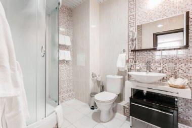 Banyo içinde odalar bir daire veya otel. Temiz beyaz havlu ve bornoz kullanmaya hazır bir askı.